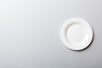 Top view of isolated of colored background empty round white plate for food. Empty dish with space for your design