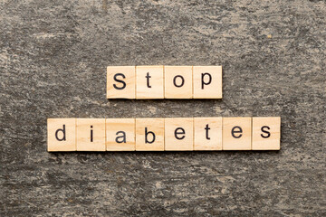 Fototapeta premium Stop diabetes word written on wood block. Stop diabetes text on cement table for your desing, Top view concept