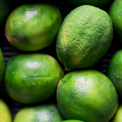 Top view of green limes on a dark background, Flat lay of organic green limes