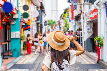 Fototapeta na wymiar Young woman tourist with backpack walking at Haji Lane in Singapore