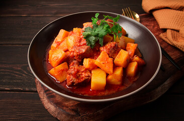 Potatoes stewed with meat, in tomato sauce, with spices and herbs, no people,