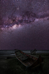 Serenity by the Shore: Fishing Boats under the Milky Way at Night in Brazil. Two Wooden Fishing Boats at the Beach.