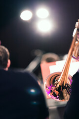 Part of a trombone visible on stage illuminated by bright stage lights during a performance
