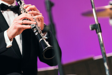 Fototapeta premium A musician playing the clarinet during a performance dressed in concert black
