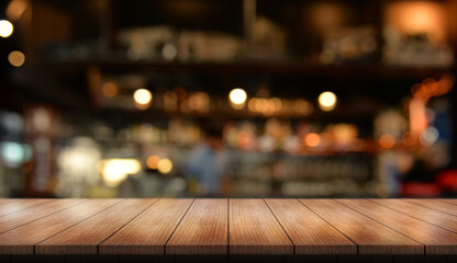 Empty wooden table top with lights bokeh on blur restaurant background.