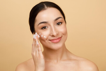Beautiful Young Indian Female Applying Moisturizing Cream On Face