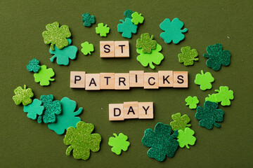 Happy St Patricks Day wooden blocks with shamrocks decor on a green background