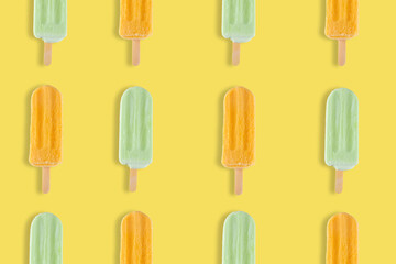Colorful summer pattern. Mango and lemon popsicles on a yellow background