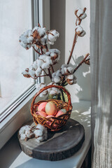Easter eggs in a wicker basket on the window still life