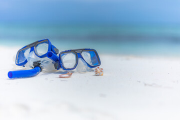 Summer sport beach activity, beach recreational concept. Diving goggles and snorkel gear on white sand near beach. Summer vacation and recreational travel adventure.  Outdoor sport wellbeing freedom - obrazy, fototapety, plakaty