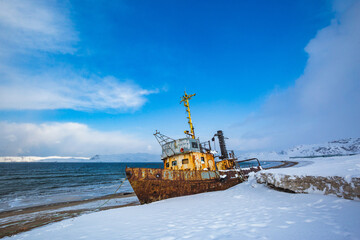 Ship near Teriberka, Barents Sea bay. Kola Peninsula winter landscape. Russia