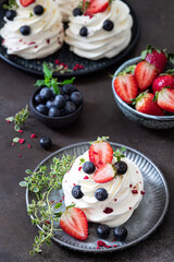 Mini pavlova meringue cake with whipped cream and fresh berries.