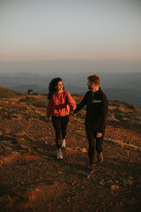 Fototapeta premium Smiling couple walking over green hills