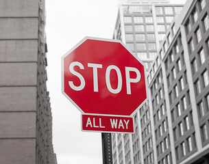 red stop all way road transport metal sign in the city with buildings on the background