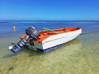 Obraz premium Old motorboat in turquoise water of the caribbean sea under tropical blue sky. Navigation, nautical and means of transport in the French Antilles.