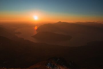 The Lombard pre-Alps near Lake Iseo, seen at sunset from one of the most beautiful viewpoints in the Province of Brescia: Punta Almana, near the town of Sale Marasino, Italy - February 2023.
