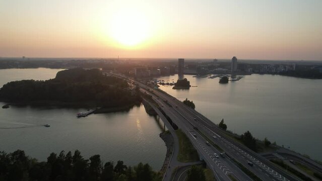 A slow flight along a highway towards the sunset in Finnish archipelago