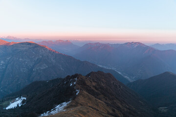 The Lombard pre-Alps near Lake Iseo, seen at sunset from one of the most beautiful viewpoints in the Province of Brescia: Punta Almana, near the town of Sale Marasino, Italy - February 2023.