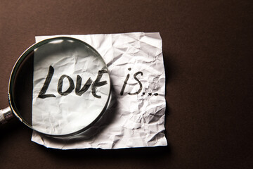 The inscription love is and a magnifier