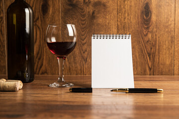 Bottle for wine with a glass and a notepad