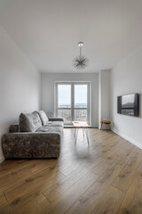 Living room with a gray sofa and a round coffee table and a huge window