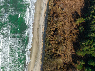 Küste mit Wellen und Strand von senkrecht oben, Luftbild