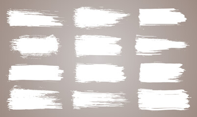 Obraz premium Paint brush. White ink grunge brush strokes. paintbrush set. Grunge design elements. Painted ink stripes. Creative isolated spots. Ink smudge abstract shape stains and smear set