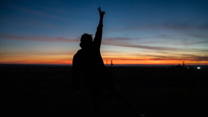 Woman dancing at sunset. Wonderful sunset woman doing yoga and sports