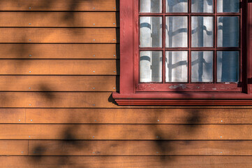 Close up details of morning sunlight on a house siding and window