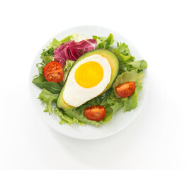 Baked egg with avocado and lettuce leaves on white plate. Bowl from healthy and balanced products. Fodmap diet concept.