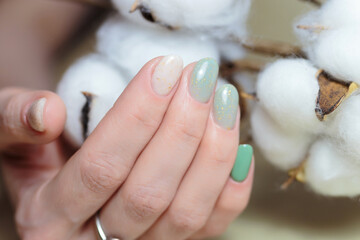 Female hands with nail design close-up. Beautiful female nails with green manicure. 