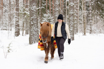 Icelandic horse and female rider in snowy Finnish forest