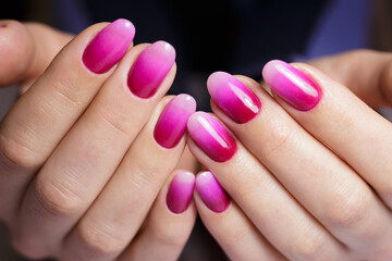 Women's hands with a gradient pink manicure. Nail design, manicure with gel polish 