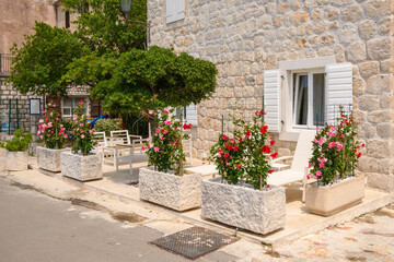 Fototapeta na wymiar Leisure terrace with sun loungers and flowers. A typical house in the picturesque village of Perast. Montenegro
