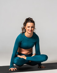 Fototapeta premium A beautiful woman is exercising in a yoga class for weight loss