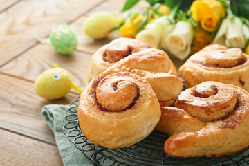 Easter breakfast Holliday concept. Easter bunny buns rolls with cinnamon made from yeast dough with orange glaze, easter decorations, colored eggs on old wooden background. Easter Holliday card.