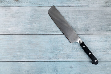 Big chef knife on the flat lay above dark blue moody background