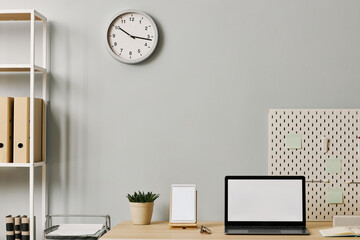Fototapeta na wymiar Minimal office setup with laptop screen mockup on desk by pastel blue wall