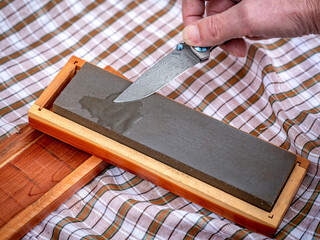 Damascus style knife on a sharpening stone