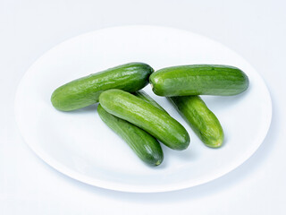 Baby cucumbers on a white place
