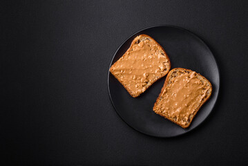 Nutritious sandwich consisting of bread and peanut butter on a black ceramic plate