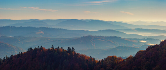 Panorama of mountain ranges on a sunny autumn morning. A beautiful haze enhances the perspective. The beauty of the Carpathian mountains