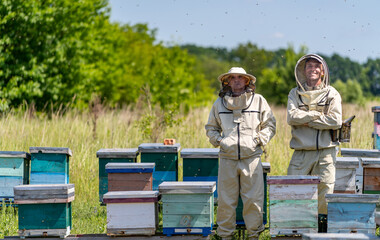 Beekeeping handsome specialists. Honey farming workers in apiary.