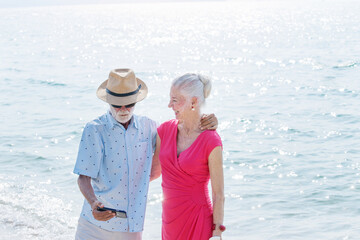 Senior couple talking at the beach on a sunny day, Happy elderly couple talking with the upset old man on tropical beach