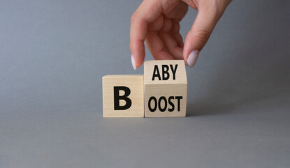 Baby boost symbol. Businessman hand Turnes cube and changes word Boost to Baby. Beautiful grey background. Business and baby boost concept. Copy space