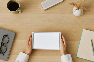 Minimal top view female hands holding digital tablet with white screen mockup