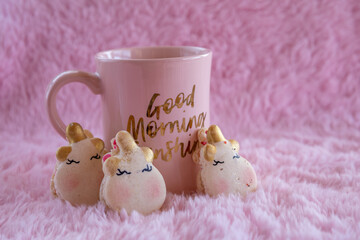 Closeup unicorn macarons and pink coffee cup on pink background