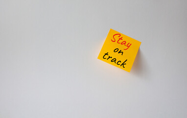 Stay on track symbol. Concept words words Stay on track on orange steaky note. Beautiful white...