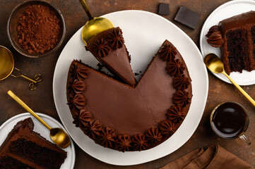 Chocolate coffee cake with chocolate cream on a plate. Pieces of cake. Top view