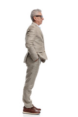 Obraz premium cool fashion old man in his 60s waiting and standing in line with hands in pockets